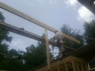 Carpenter setting a ridge beam over a new addition frame — Ice Dam Removal by Roofing Brothers in Roann