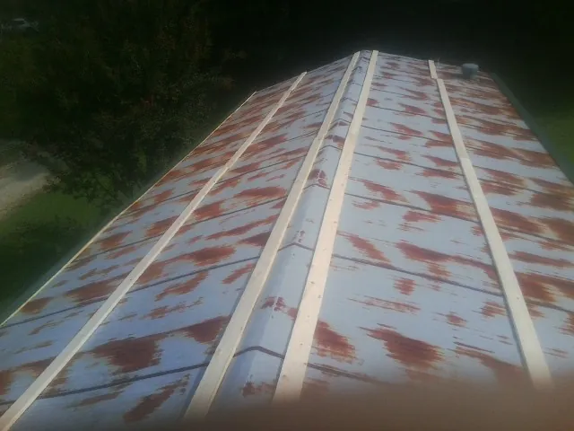 Rusted metal roof panels with new wood purlins before replacement — Storm Damage Roof Repair in Roann by Roofing Brothers